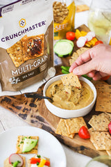 Crunchmaster galleta en mano para comparar tamaño y porción práctica