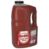 Frank's RedHot envase frontal mostrando el galón y la marca ligera picante