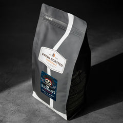 Fresh Roasted Coffee granos enteros cerca resaltando frescura y aroma