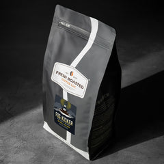 Fresh Roasted Coffee mano sosteniendo granos destacando calidad y textura