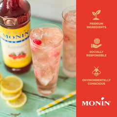 Monin jarabe frambuesa botella junto a vaso para referencia de tamaño