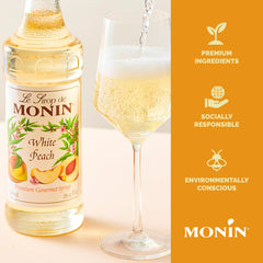 Botella Monin melocotón junto a vaso para escala y tamaño claro