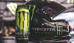 Comparación de tamaño de la lata Monster Nitro 16 oz junto a objetos cotidianos para escala