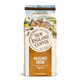 New England Coffee paquete frontal mostrando 18 oz y sabor avellana