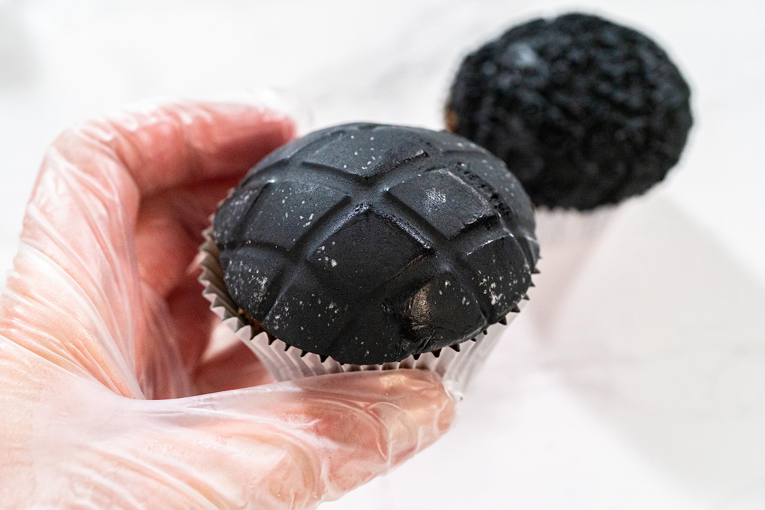 Manos trabajando fondant Bakerpan junto a una libra para referencia de tamaño