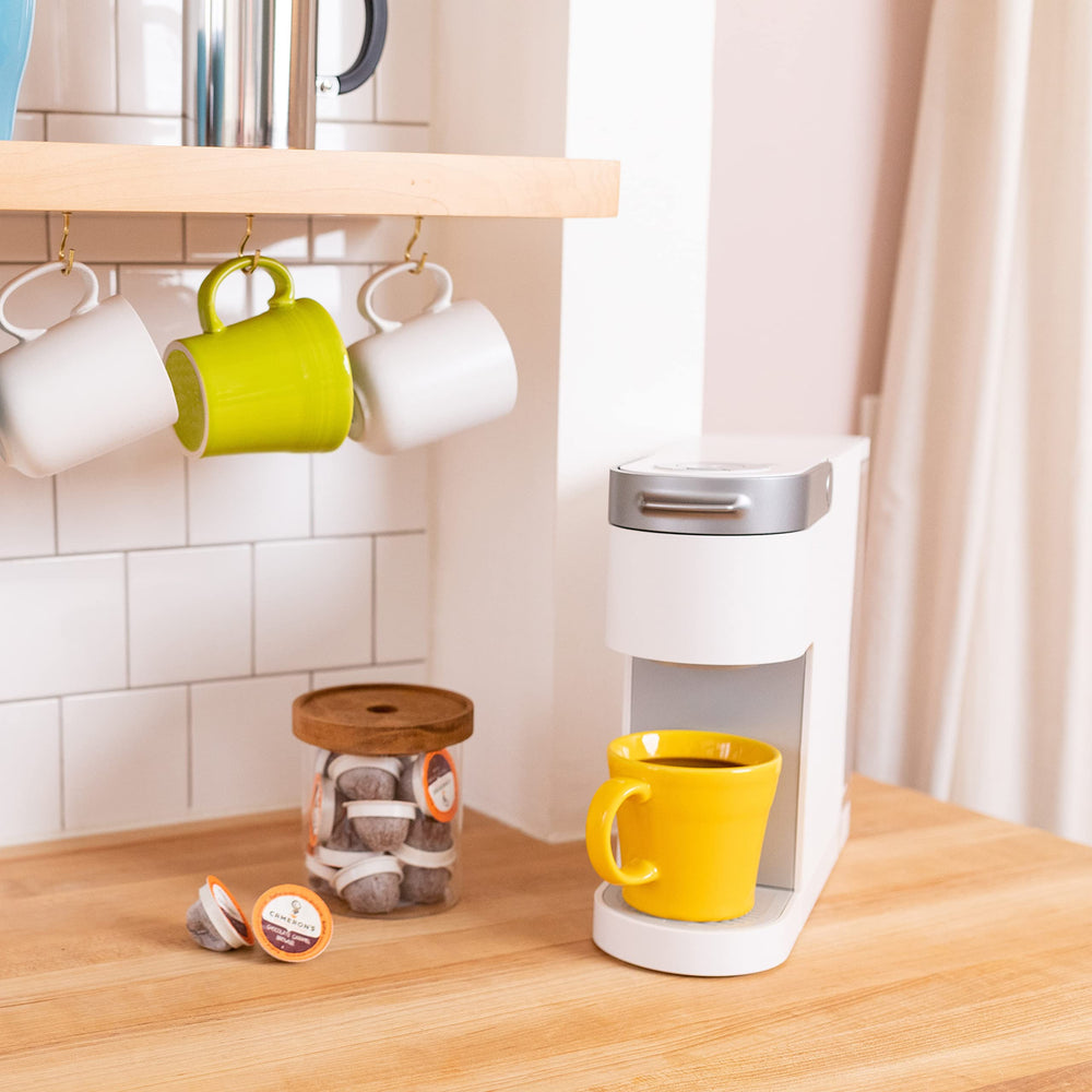 Cameron's Coffee cápsula insertada en máquina Keurig demostrando compatibilidad