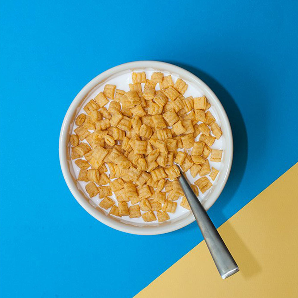 Cap'n Crunch en escena de desayuno familiar sobre mesa, transmite facilidad y diversión