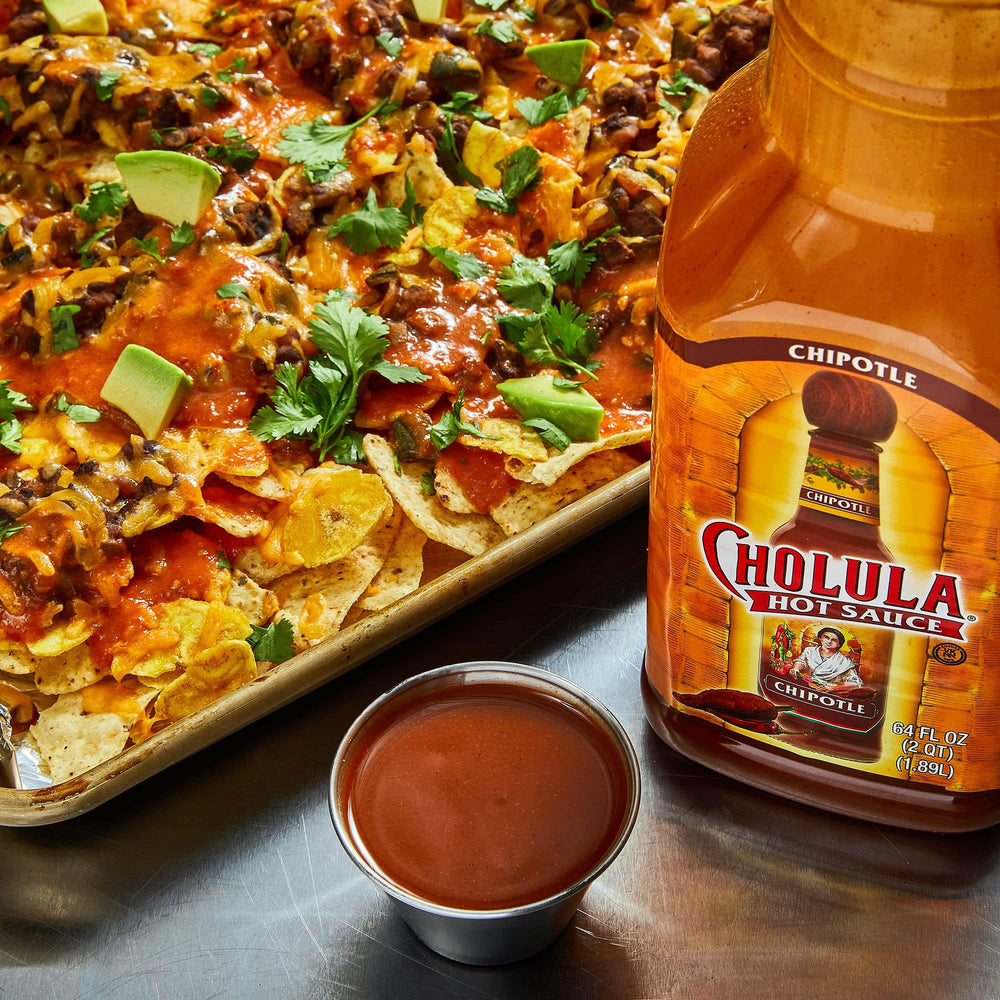 Cholula 64 oz sostenida por mano para comparar tamaño práctico
