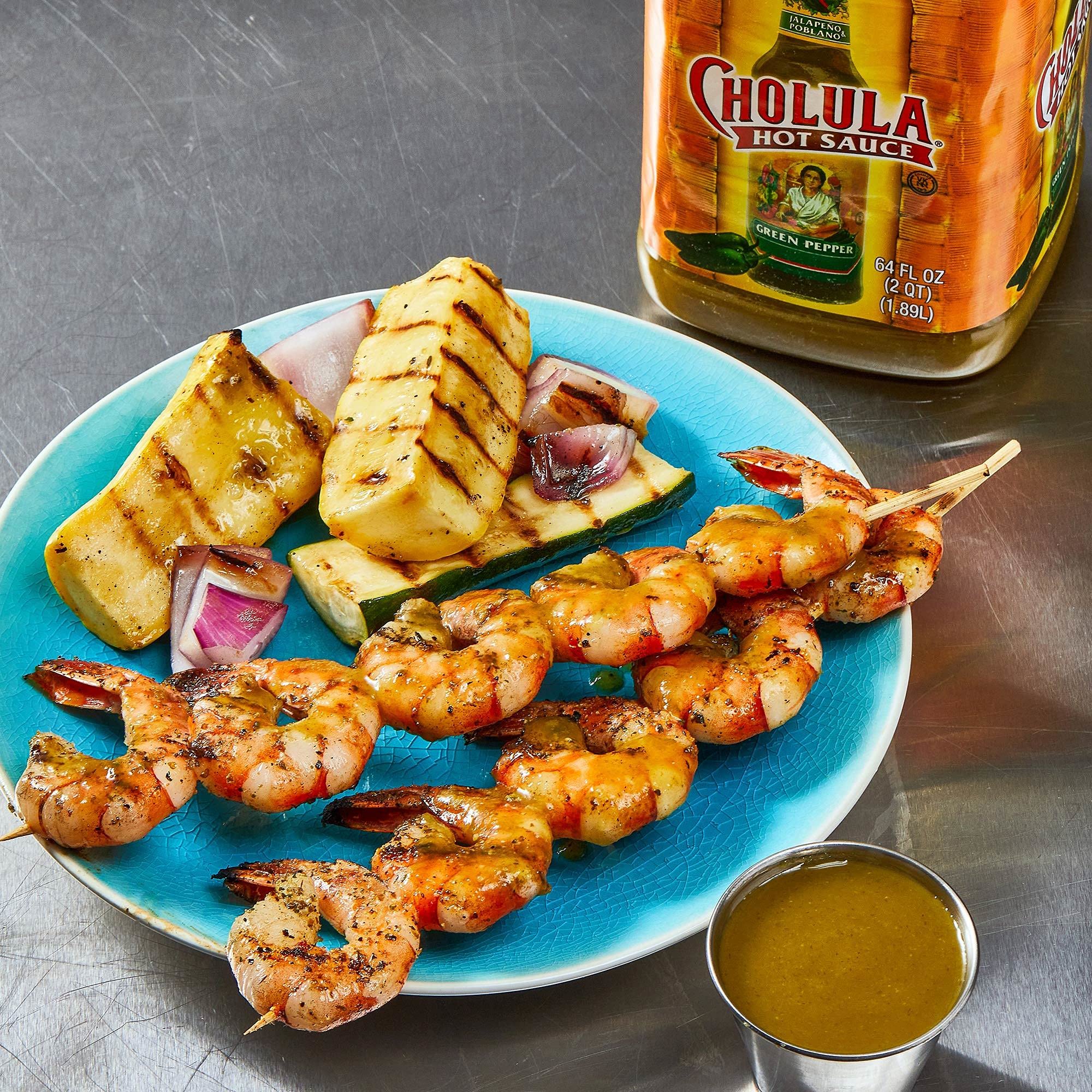 Cholula comparada con manos para mostrar tamaño de 64 fl oz y rendimiento por porción
