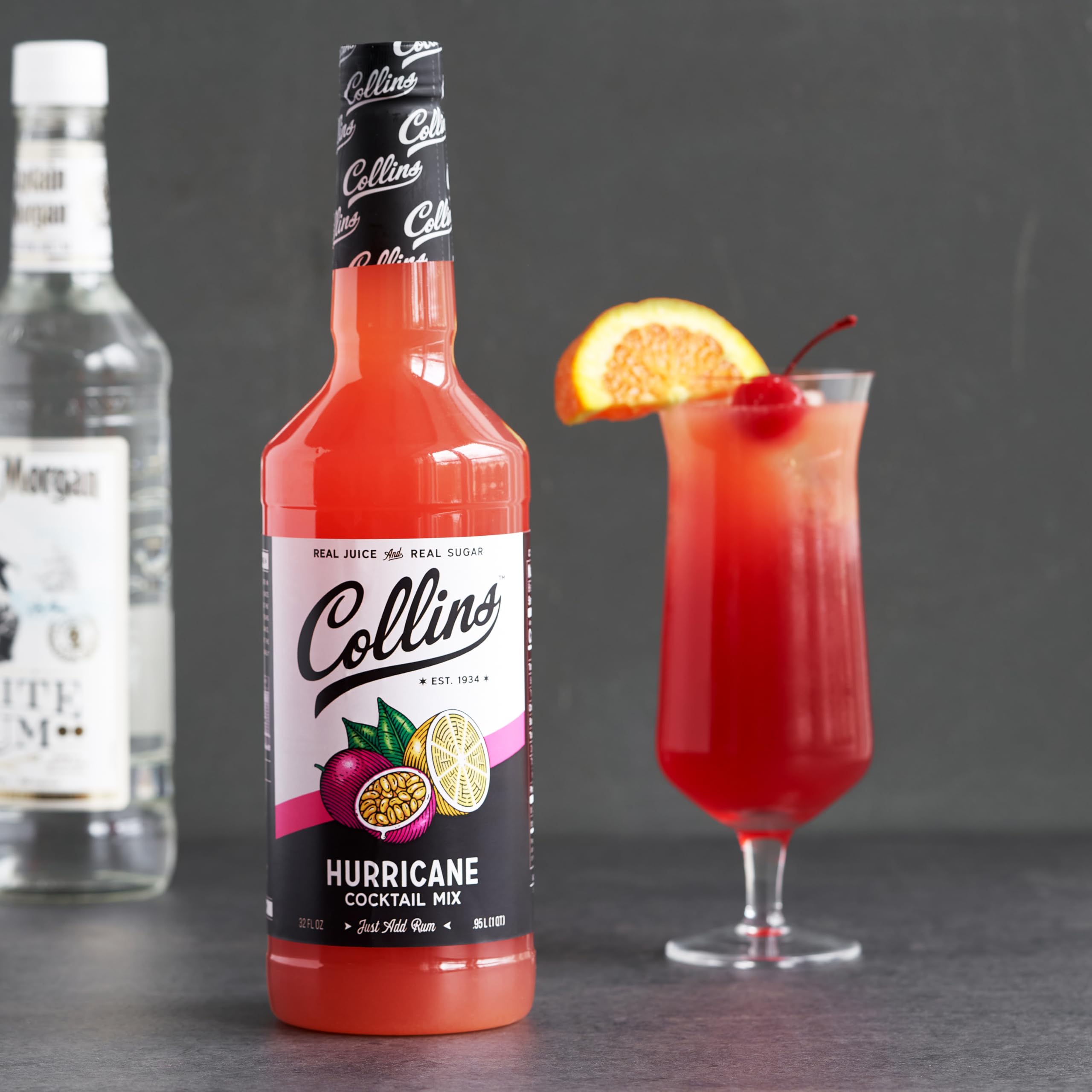 Collins Hurricane botella junto a una copa para comparar el tamaño de 32 fl oz