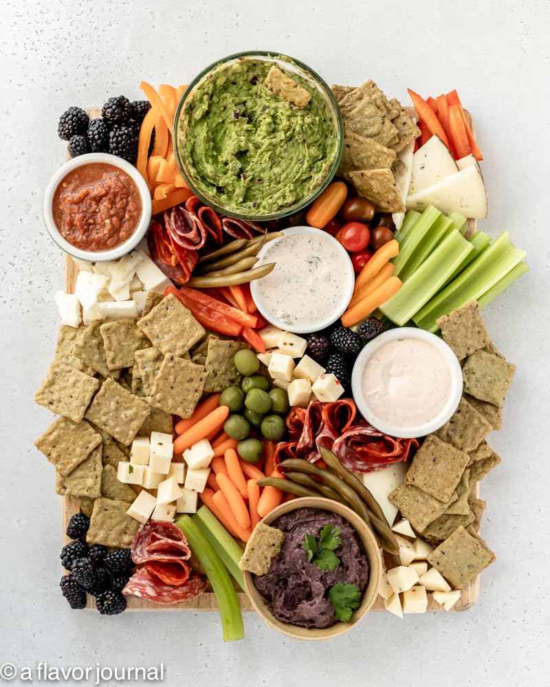 Crunchmaster galletas servidas en tabla con toppings mostrando versatilidad para aperitivos