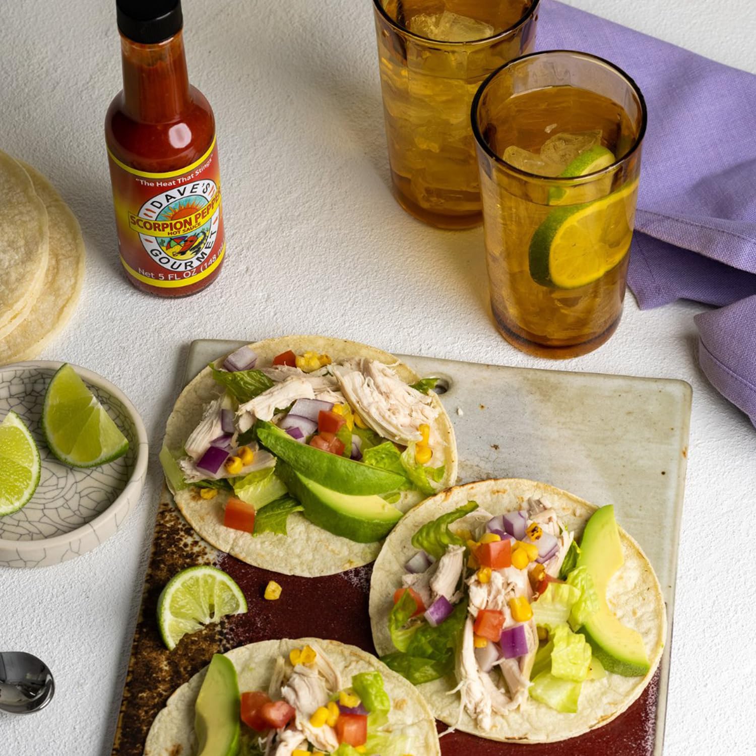 Dave's Gourmet botella en mano para comparar tamaño de 5 oz y porciones manejables