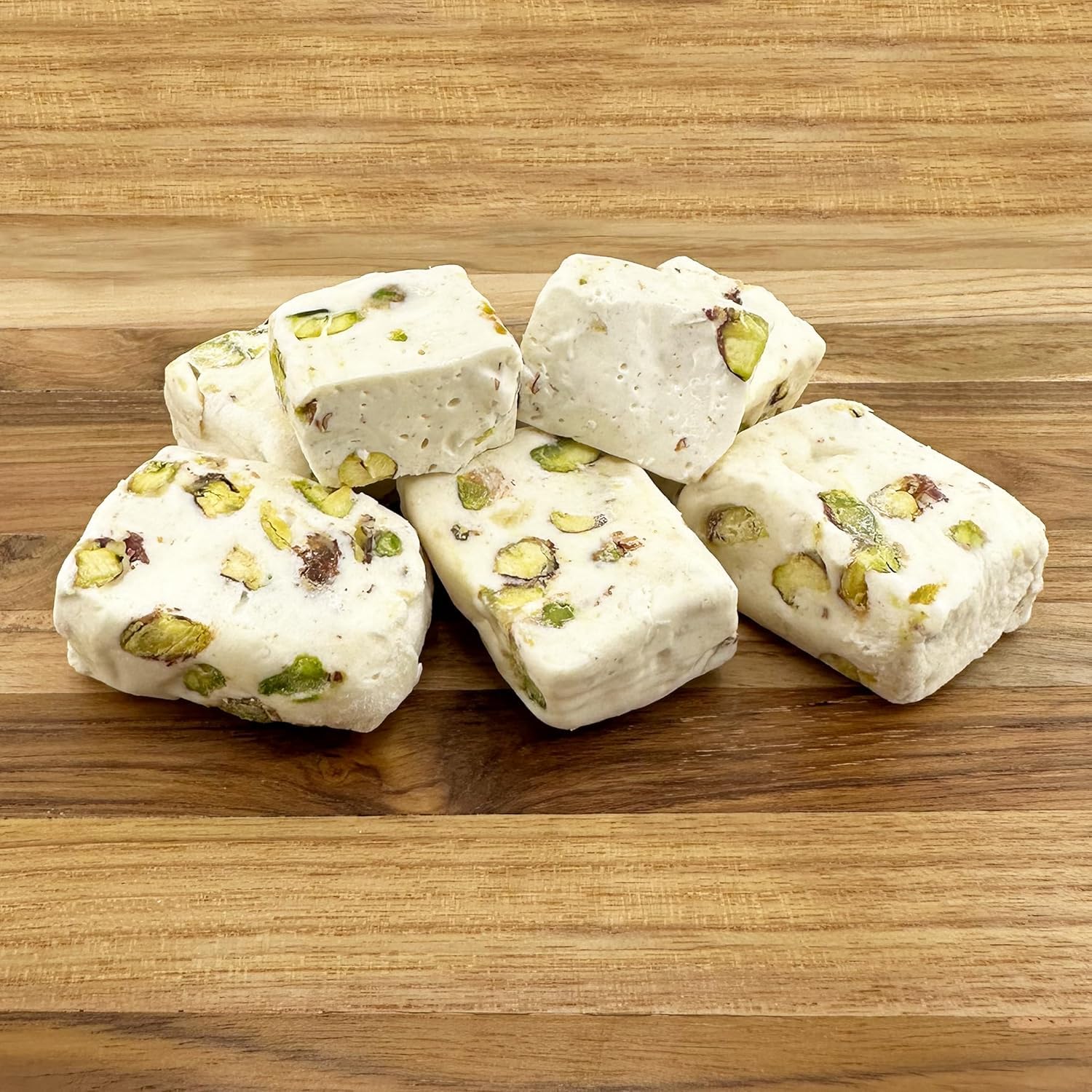 FirstChoiceCandy primer plano de turrón abierto mostrando textura blanda y pistachos
