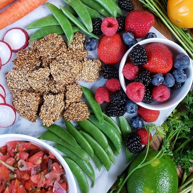 Tabla de snack con Flackers, quesos y frutas como inspiración de consumo saludable