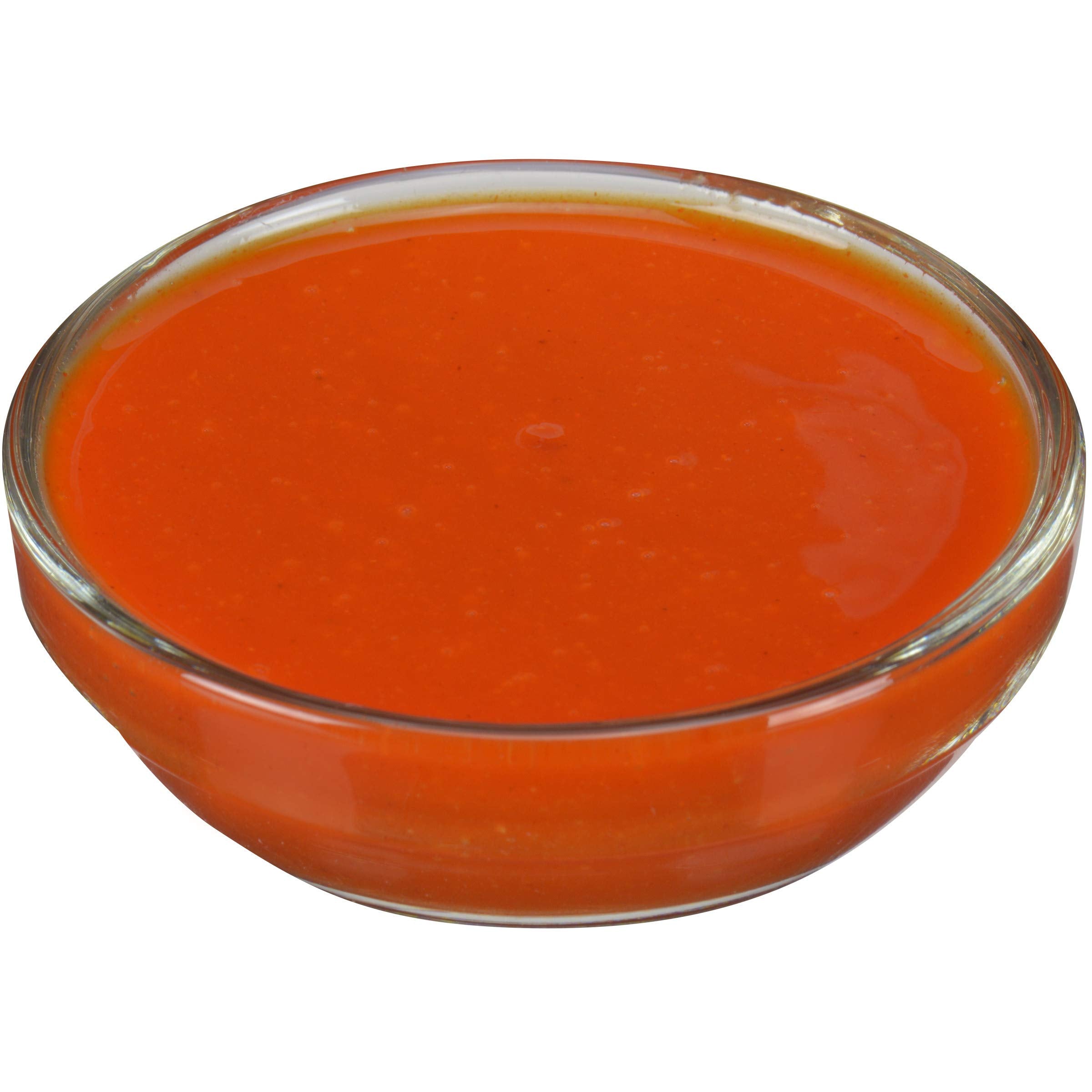 Cocinero profesional usando Frank's RedHot en línea de montaje para consistencia