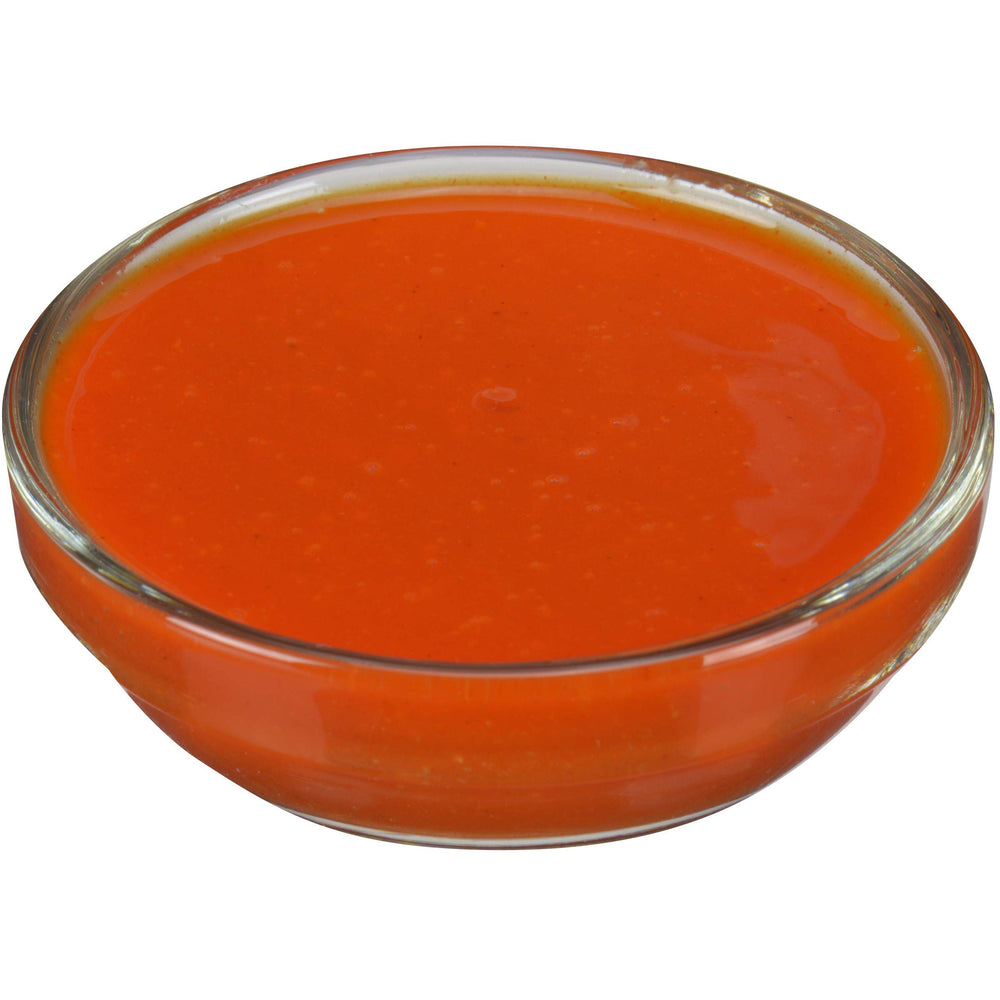 Cocinero profesional usando Frank's RedHot en línea de montaje para consistencia