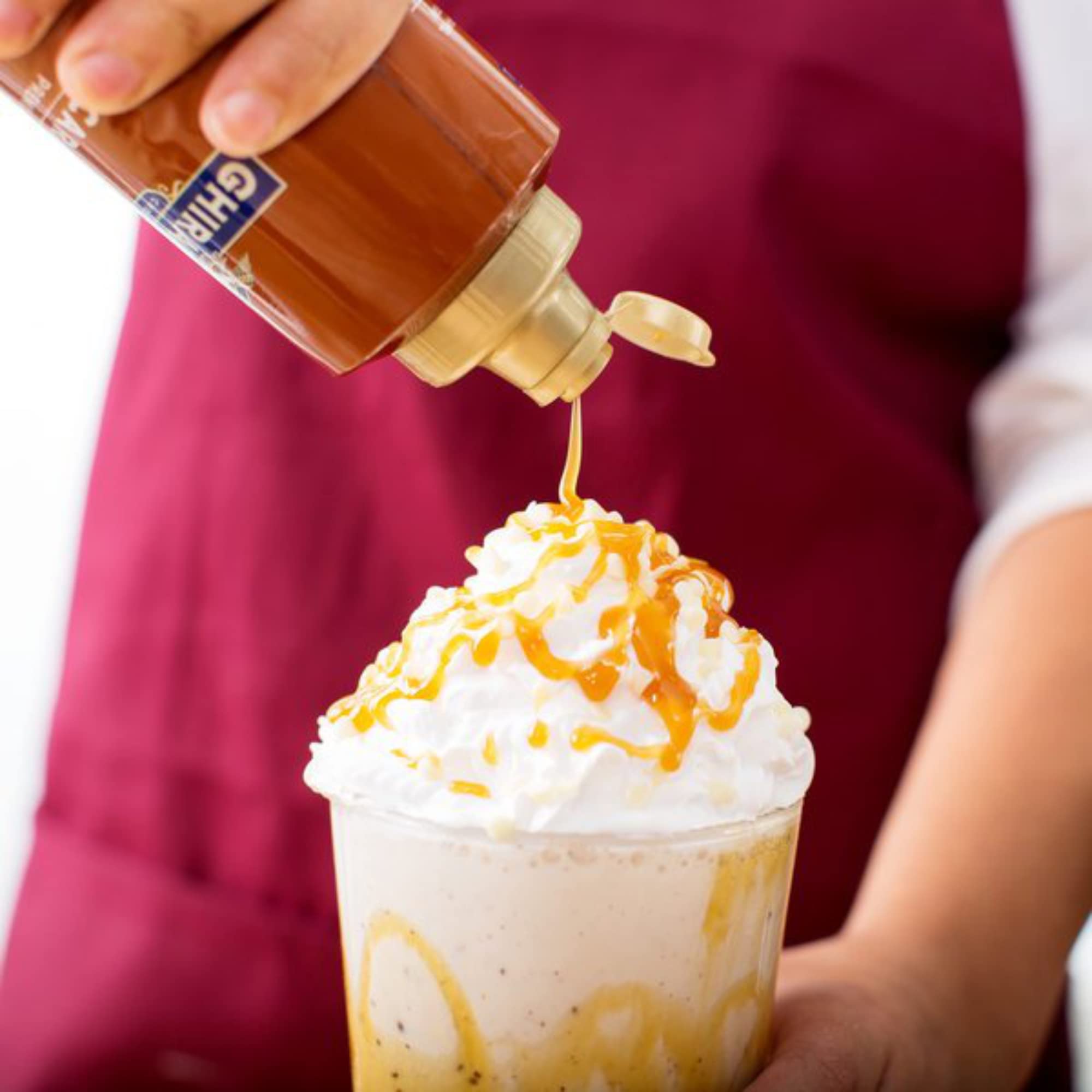 Ghirardelli salsa de caramelo vertida sobre helado para un topping atractivo