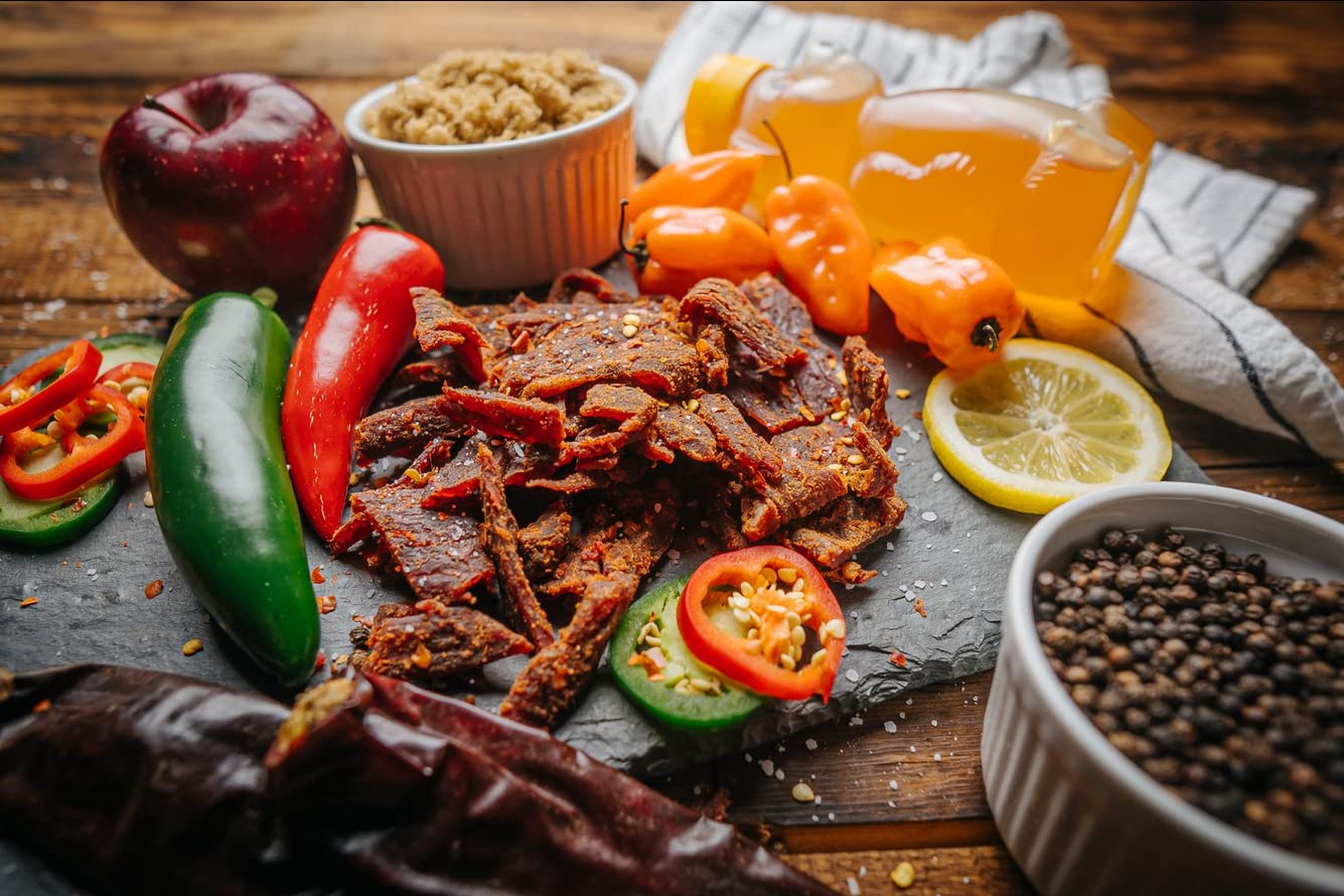 Glenwood Snacks tiras de jerky en mano para comparar tamaño y porción práctica