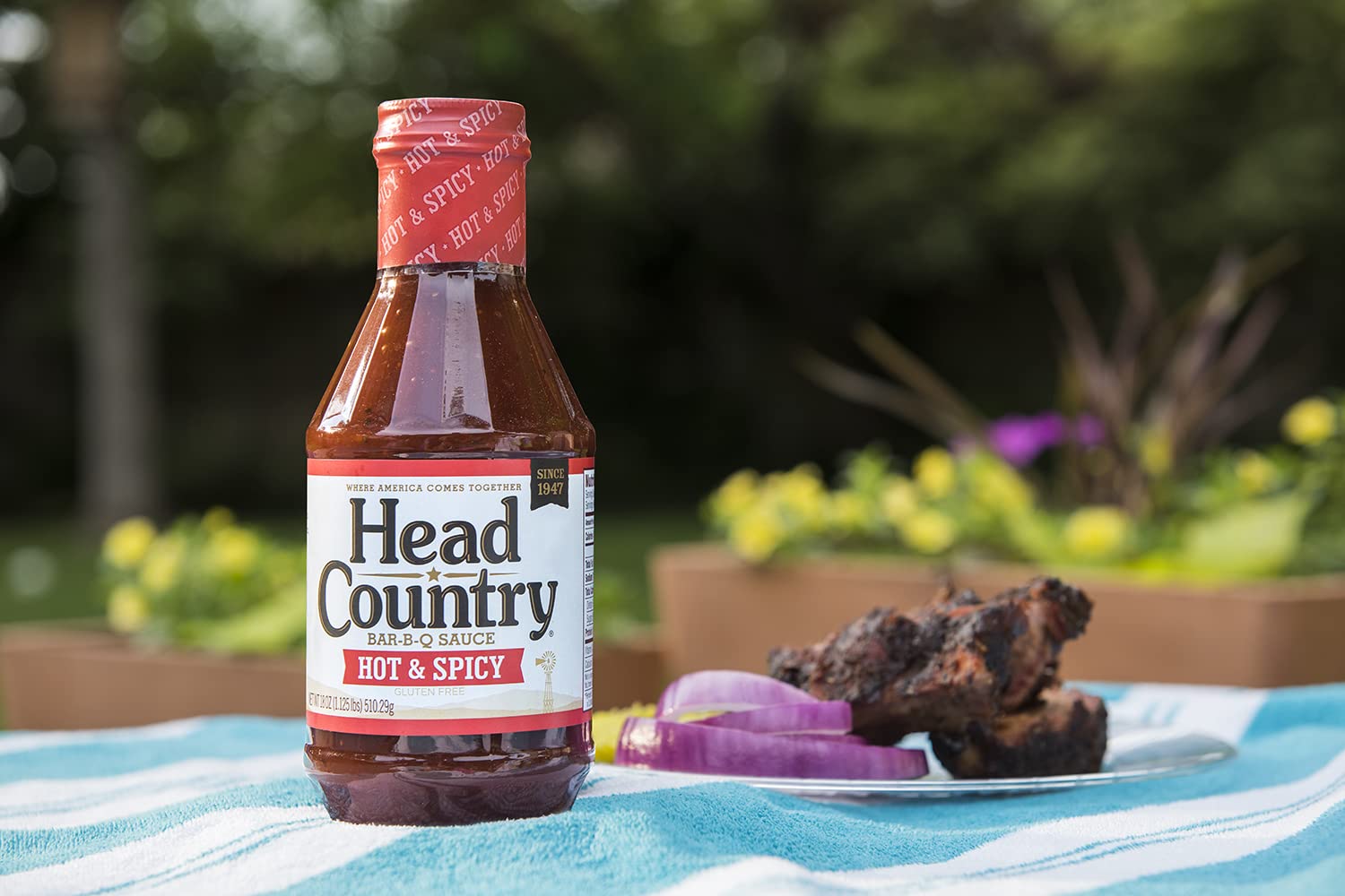 Head Country pincelando costillas en parrilla para sabor intenso