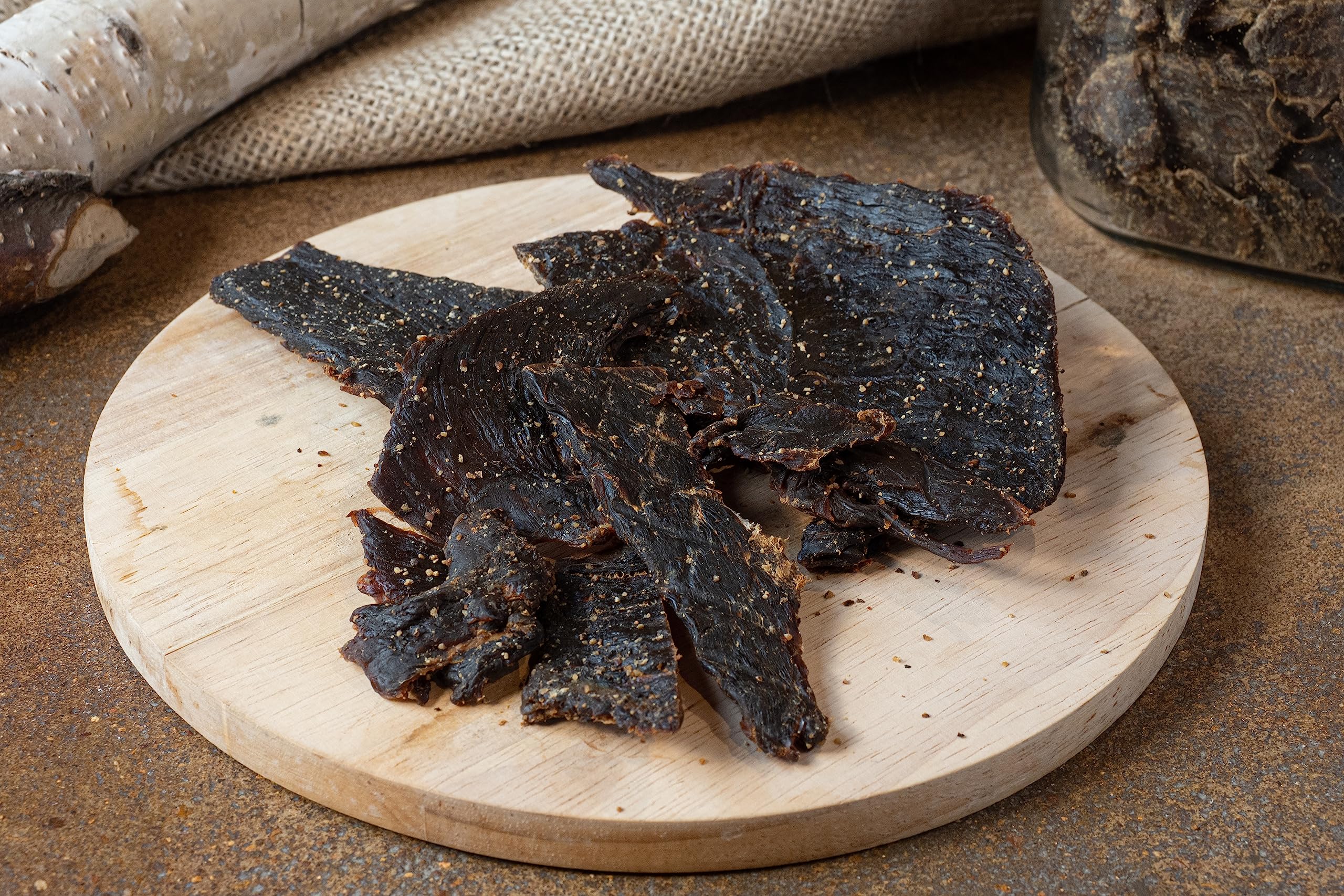Jerky.com textura cercana de tiras de venado, detalle de carne magra y firme