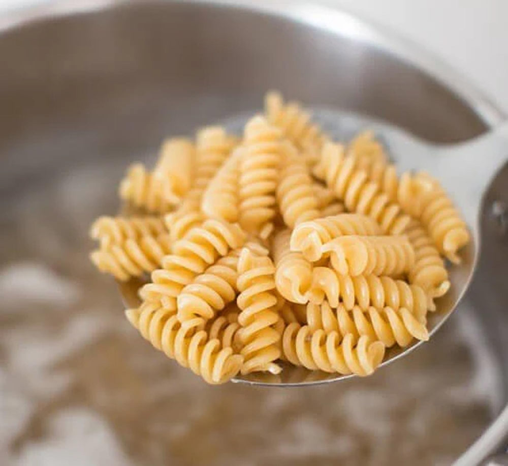 Comparación de tamaño del fusilli Jovial Einkorn junto a una mano para apreciar la escala de la pasta