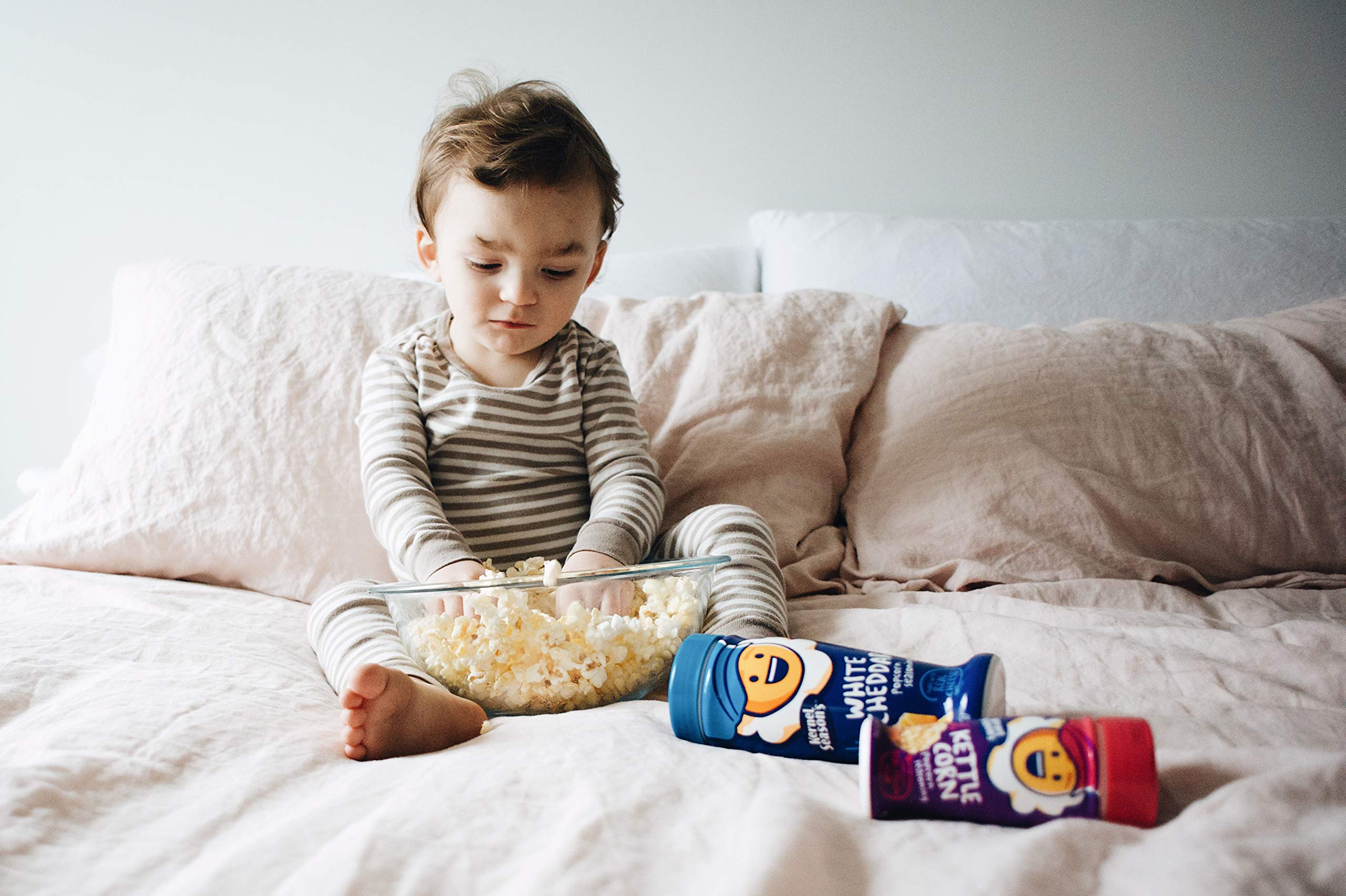 Kernel Season's manos espolvoreando sobre snack indicando facilidad de uso
