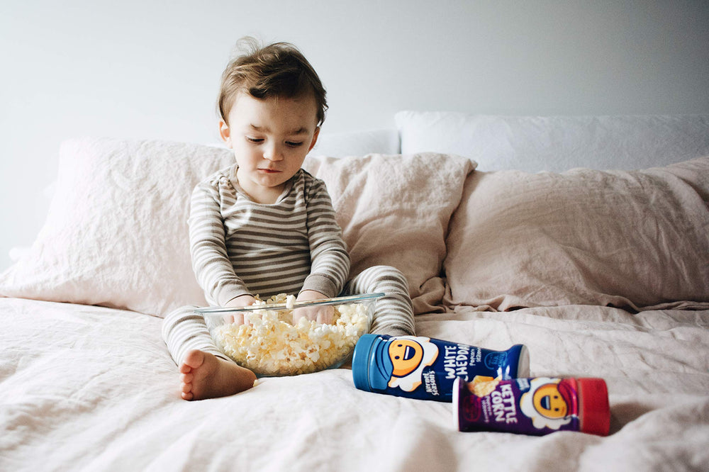 Kernel Season's manos espolvoreando sobre snack indicando facilidad de uso