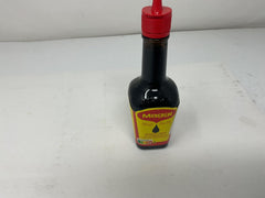 Botella Maggi junto a una cuchara para comparar tamaño y porción