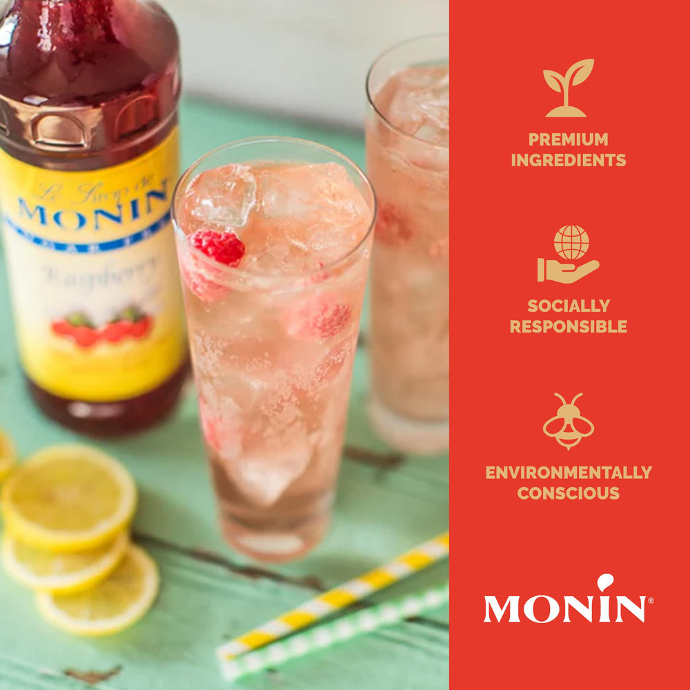 Monin jarabe frambuesa botella junto a vaso para referencia de tamaño