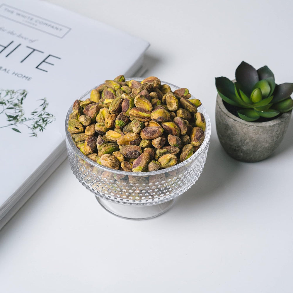 Nichols Farms pistachos en mano para apreciar tamaño y porción práctica