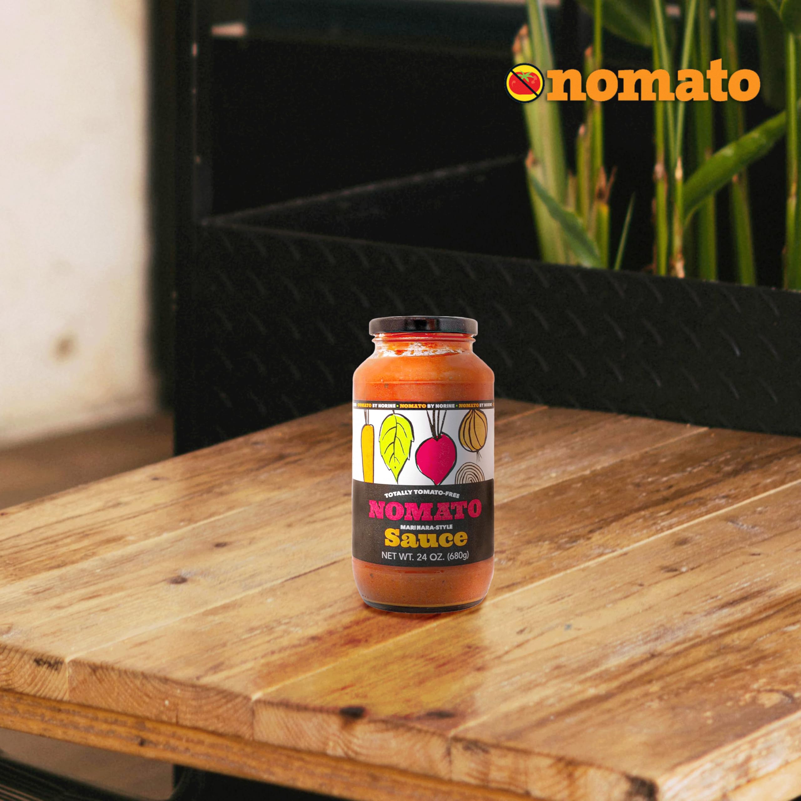 Nomato frasco en mano para comparar tamaño 24 oz, marca Nomato facilita cálculo de porciones