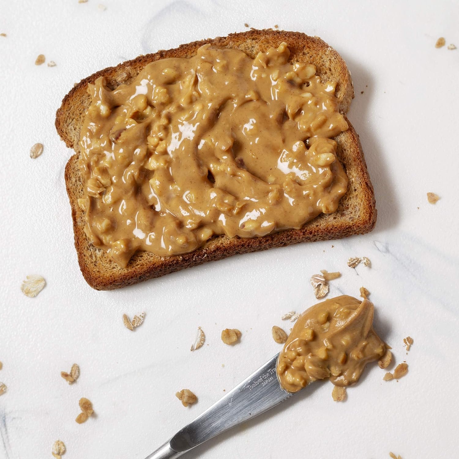 Peanut Butter & Co. frasco junto a mano para comparar tamaño real