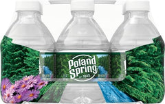 Poland Spring botellas en mesa de evento, ideal para catering y escuelas
