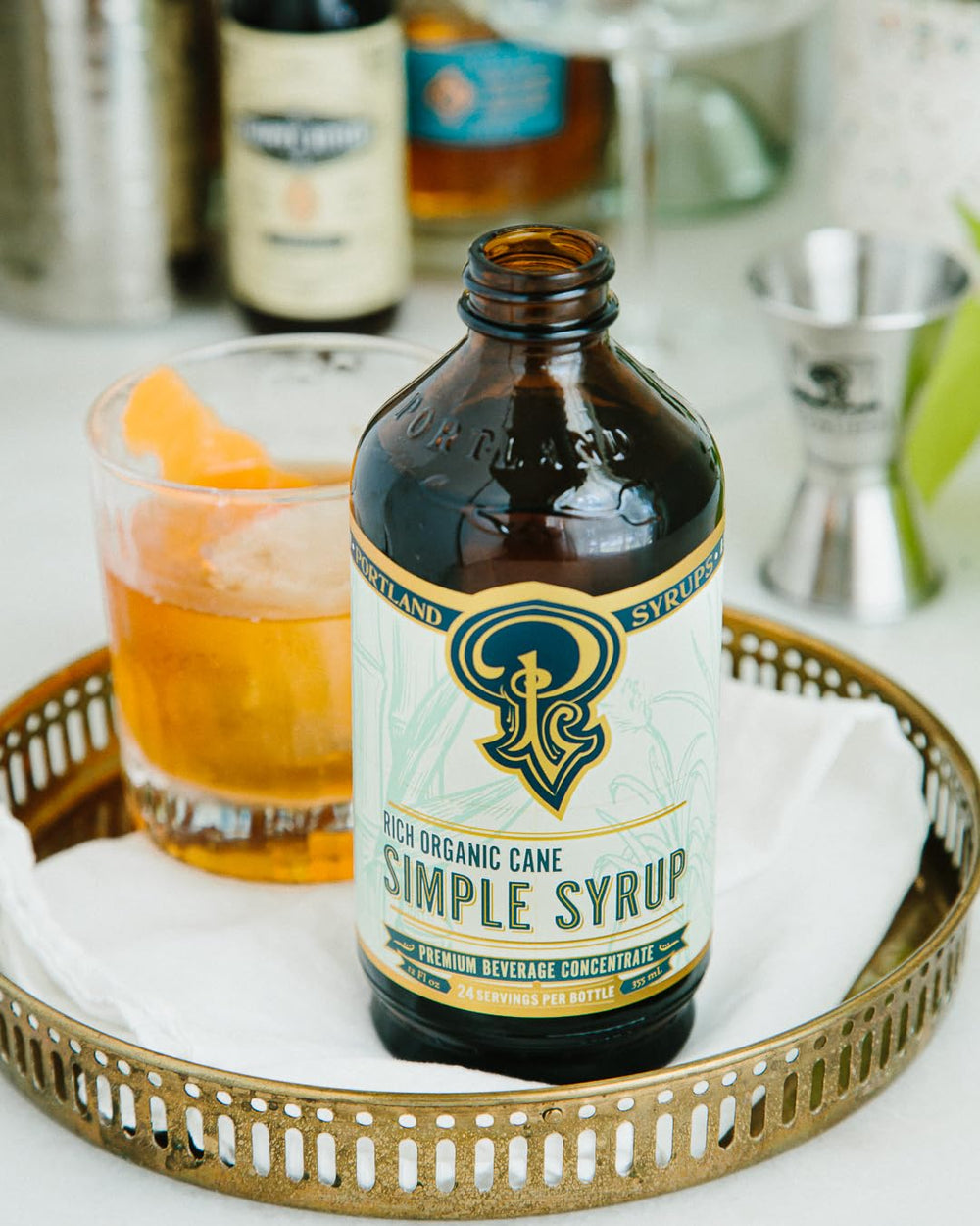 Portland Syrups botella junto a objetos para comparar escala y rinde