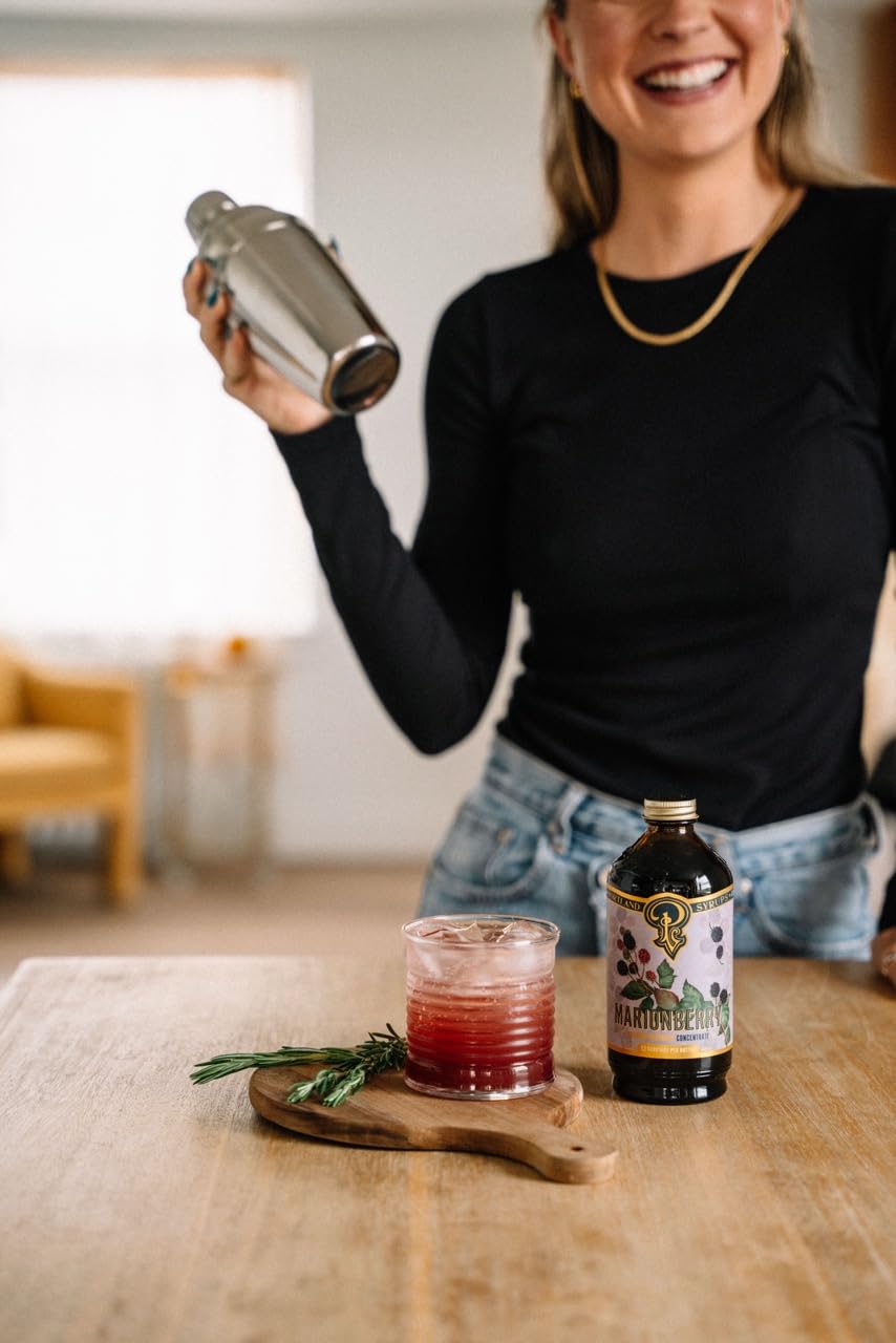 Portland Syrups botella en mesa rústica con frutas, evoca sabor del Pacífico Noroeste
