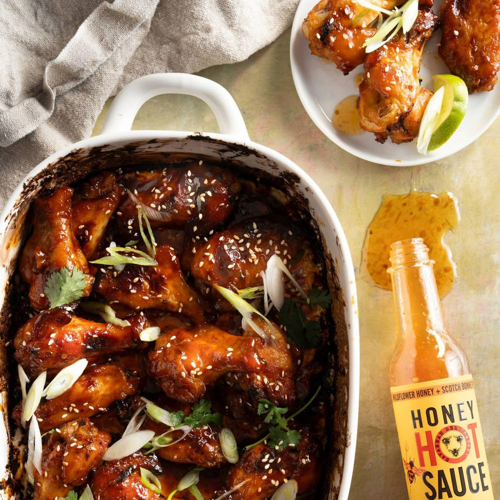 Savannah Bee Company frasco junto a ingredientes picantes como scotch bonnet