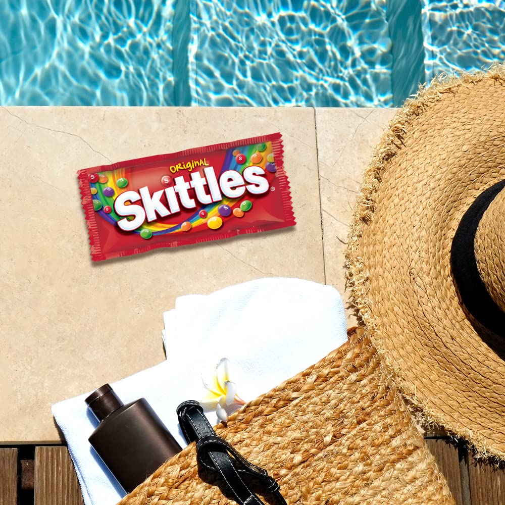Skittles paquete individual sostenido en mano fácil de llevar y compartir