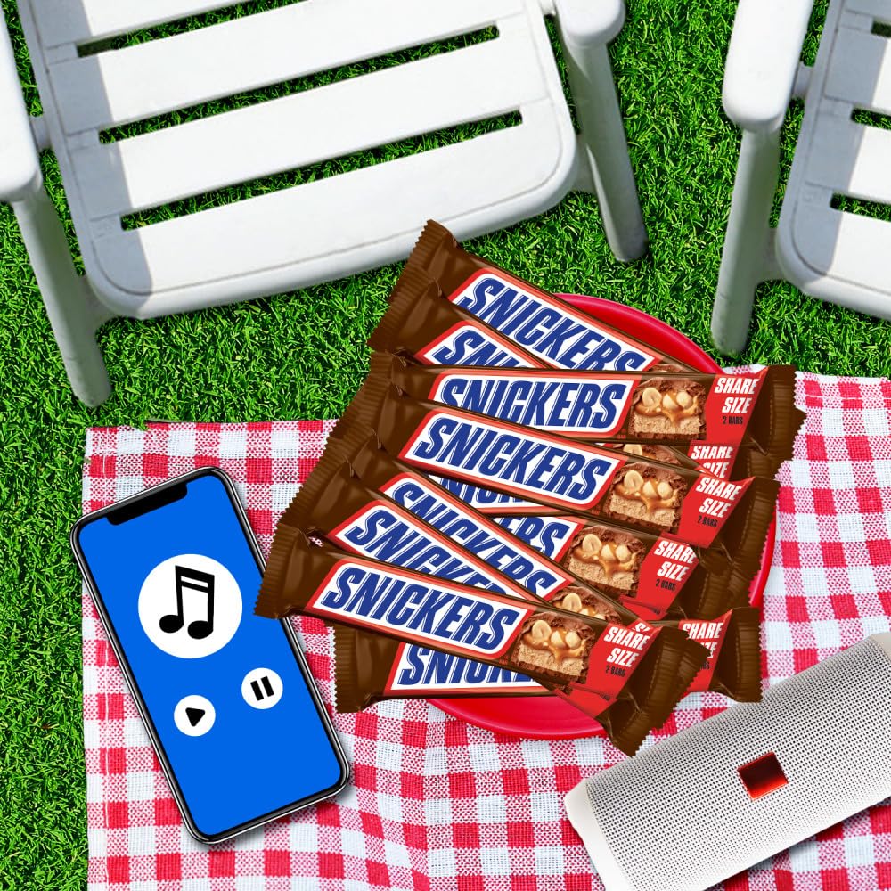 Snickers barra junto a mano para ver escala y tamaño práctico para llevar