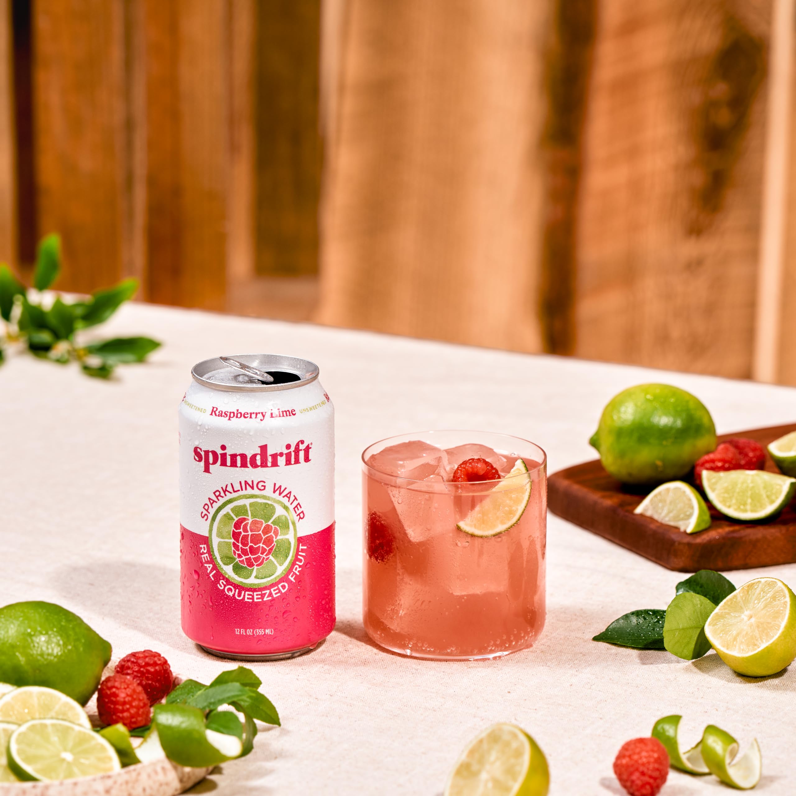 Frambuesas y limas frescas junto a lata Spindrift para naturalidad