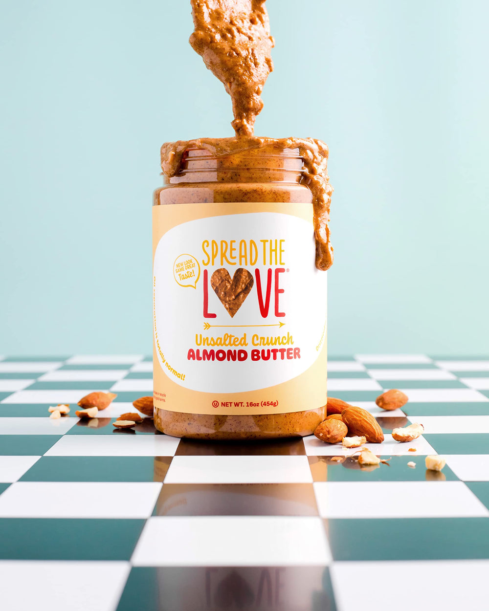 Spread The Love frasco al lado de una mano para comparar tamaño práctico