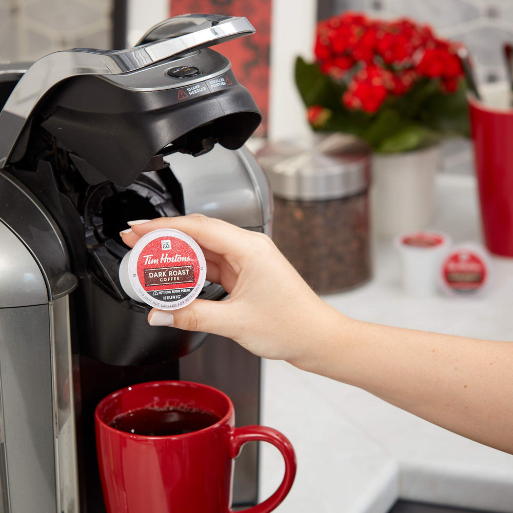 Tim Hortons cápsula junto a mano para escala y facilidad