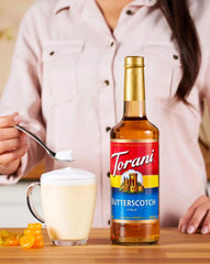 Torani jarabe vertido en latte realzando sabor y crema en la taza