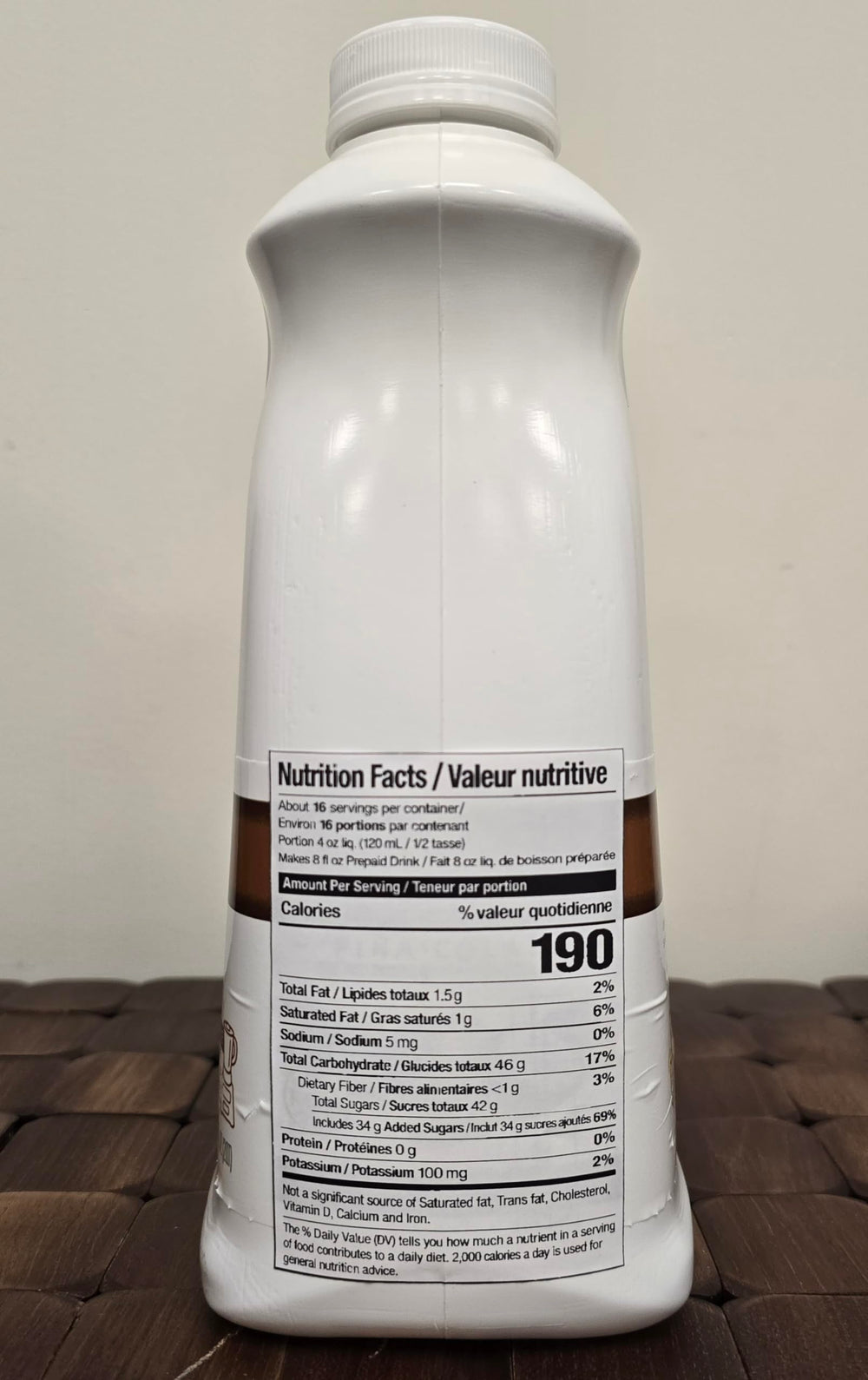 Torani envase 64 fl oz en manos, demostrando rendimiento por porción
