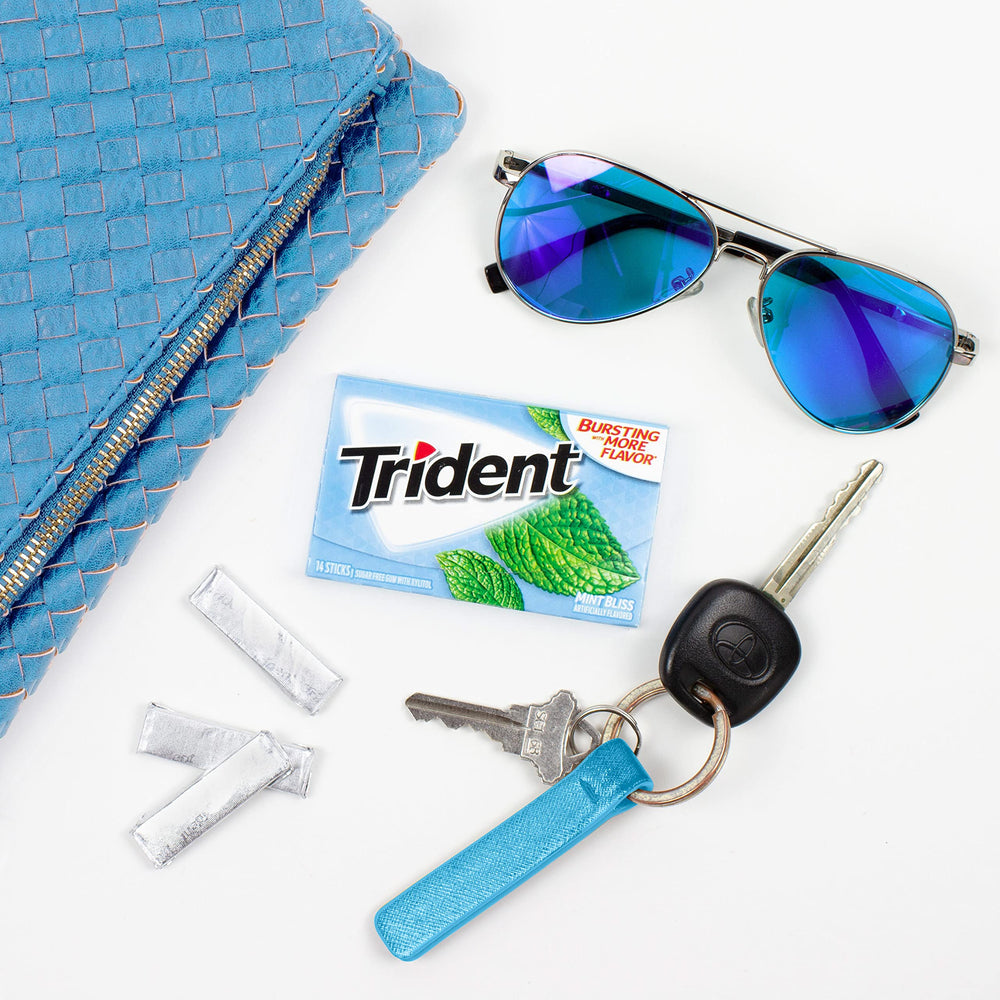 Comparación de tamaño de Trident Mint Bliss con una mano, tamaño compacto