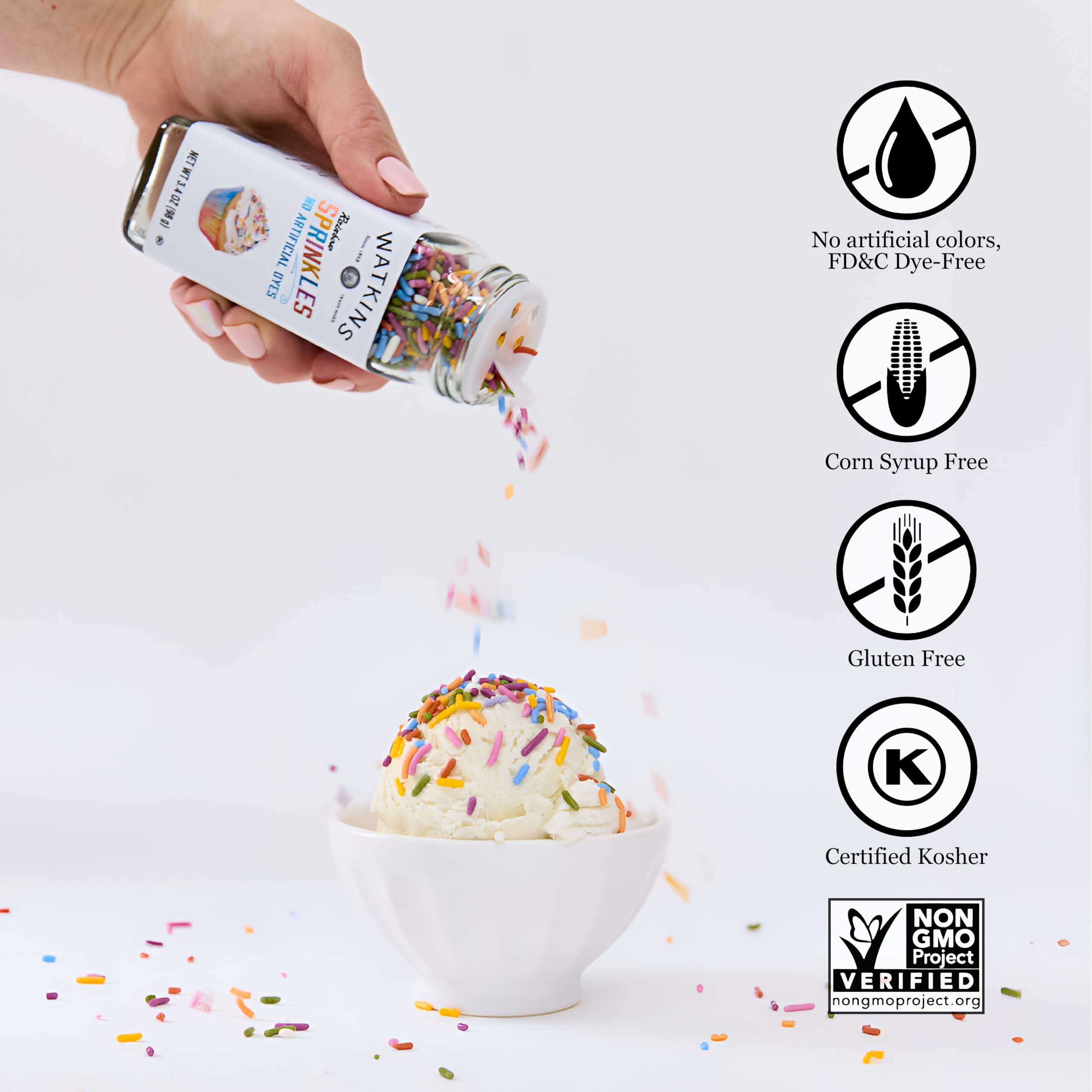 Watkins decorando pastel con sprinkles, acabado profesional y alegre